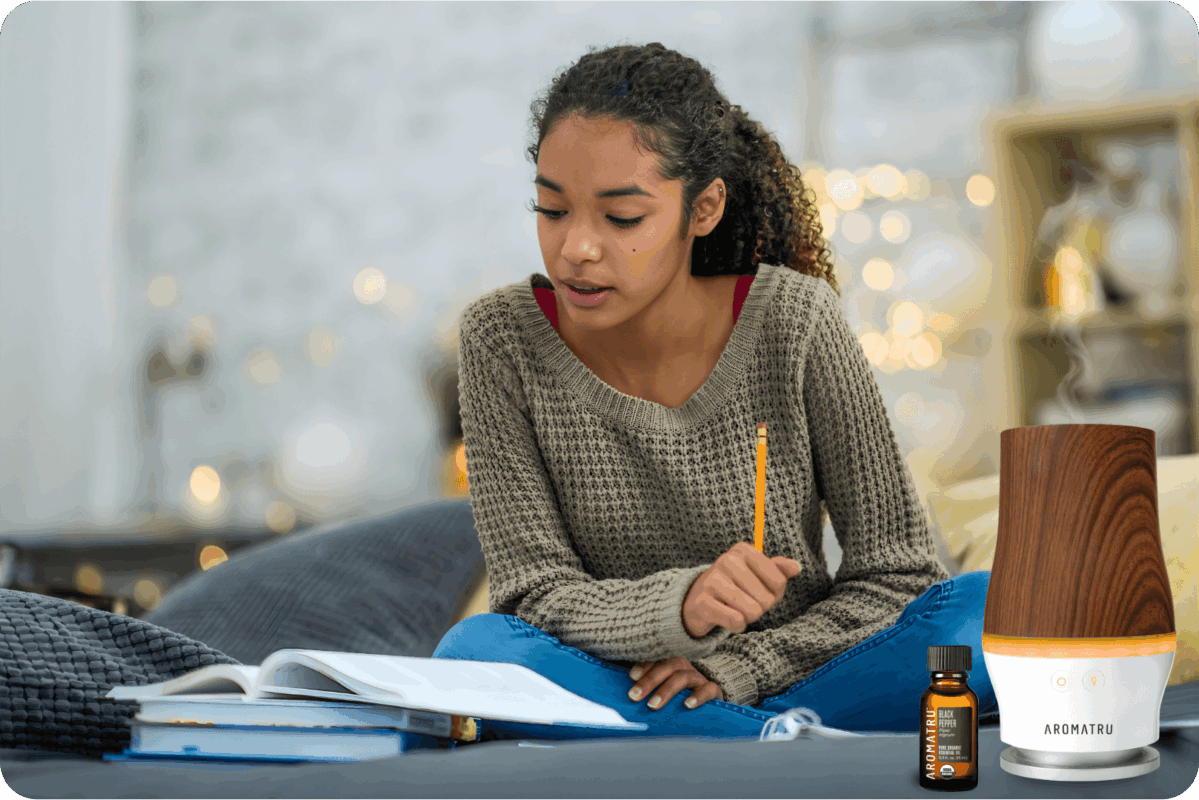 young woman studying alongside an AromaTru diffuser